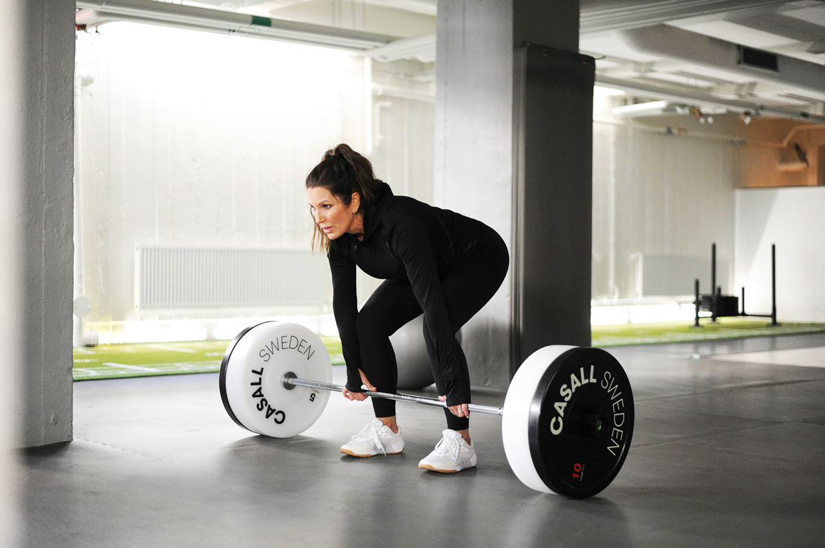 Tränare utför ett träningspass i ett gym, använder träningsutrustning.